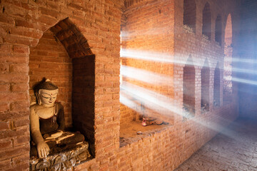 Light rays in a temple with a Buddha statue 
