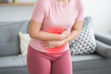 Stomach ache, symptoms of gastritis or pancreatitis, woman with abdominal pain at home interior