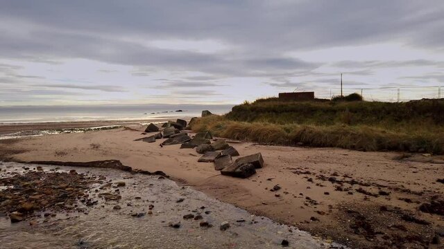 Tiel burn flowing into the Firth of Forth through Kirkcaldy beach with antitank concrete blocks from WW2 on the far bank