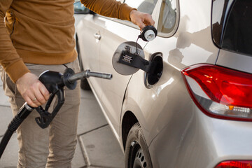 Car refueling on the petrol station. Hand refilling the car with fuel. Close up view. Gasoline,...
