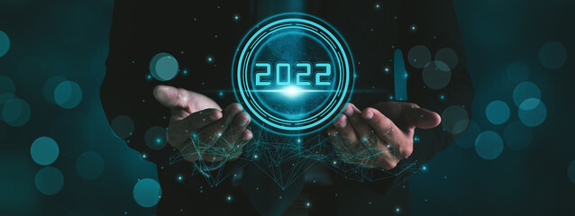 Businessman hand holding 2022 number,happy new year concept digital trends,industry and business...