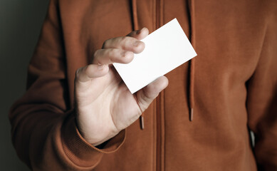 Man's hand showing blank white business card. Man holding business card.