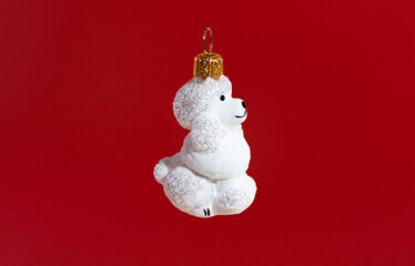 Glass toy dog for the Christmas tree on a red background. located on a green background