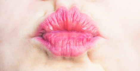 Close up of a beautiful caucasian girl. Lips blowing a kiss with red lipstick.