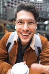 Man wearing glasses talking something to the camera with pleasure smile while traveling