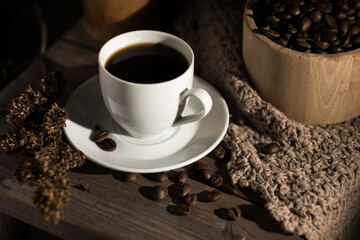 Espresso coffee cup and coffee beans on an old wooden background. Dark background.