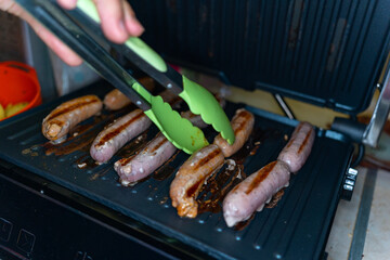 pork and beef sausages made on an electric grill