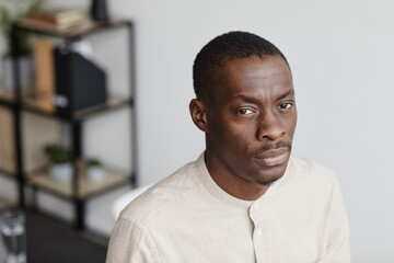 Minimal portrait of black man looking at camera in home office, high angle, copy space
