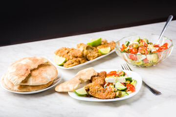 Baked fish served with vegetable salad with feta cheese