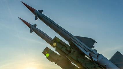 Two combat missiles aimed at the sky. Old ballistic missile launcher on blue sky background.