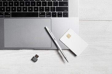 Blank credit card, pen, flash drive and laptop keyboard on wooden background. Online business concept. Flat lay.