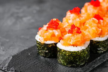 appetizing sushi roll maki with salmon on a black stone plate © Narsil