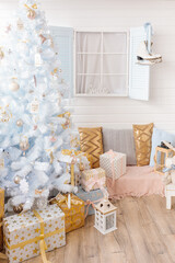 White Christmas tree decorated with silver golden pink Christmas balls and beautiful glass balls on sparkling and fairy white blue branch, decorative lights. Photo