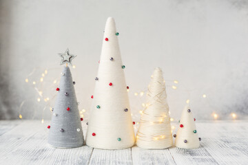 Handmade Christmas trees and garland. Yarn wrapped XMAS cone trees with minimalistic decor. XMAS gifts. DIY concept