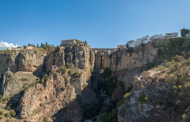 Fototapeta na wymiar Aerial view at the iconic New Bridge above the gauge, natural geological phenomenon, erosion cliffs around the Ronda city, touristic travel destination, El Tajo Gorge