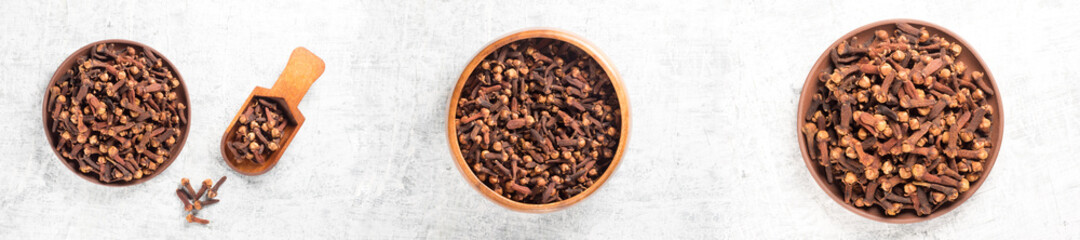 Set of spice clove (Syzygium aromaticum) in wooden scoop, bowl, clay plate, scattering on white concrete background,. Close up, macro. Flat lay