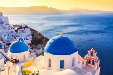 Famous Santorini iconic view. Blue domes and traditional white houses during sunset. Oia village, Santorini island, Greece.
