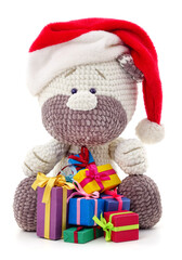 Toy tiger in a Christmas hat and gifts.