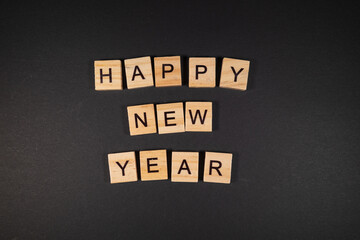 The words "Happy new year" were placed on a dark base with wooden letters