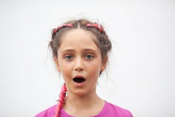Emotional portrait of a 9-year-old girl with red pigtails