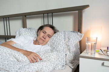 aging senior woman female in bed at home flat, tired sick ill alone retired and resting virus...