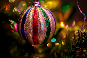 Obraz premium Colorful Christmas ball on a festive tree. Bokeh. Blurred background. Shallow depth of field. Macro. Soft focus 