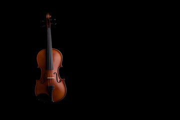Fototapeta na wymiar A violin or viola with four strings with a beautiful soft light hitting it on a black background. No.16