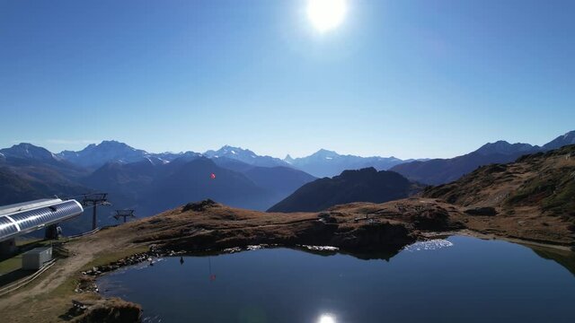 Establishing huge mountain scene with idyllic lake and Swiss flag, aerial dolly