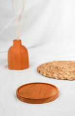 minimalist setting of product platform shot for product exhibition. the arrangement of wooden placemat and vase on white decorated with wicker placemat.
