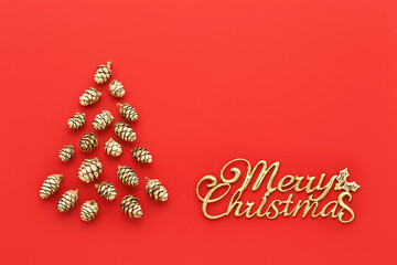 Fototapeta na wymiar Christmas tree made from golden cones and text Merry Christmas on a bright red background.