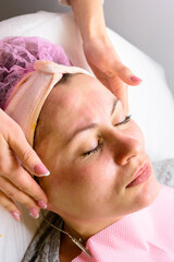 Facial massage at the beautician at the reception, visiting a beauty salon, a sense of relaxation.