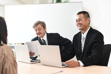 会議をする複数人のビジネスマンのシニア男性とミドル男性達