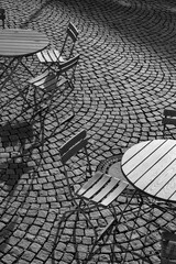 Outdoor German cafe seating with round tables and wooden   chairs