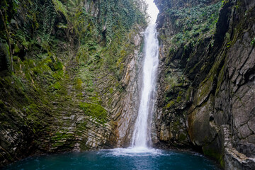 Fototapeta na wymiar A picturesque waterfall in the jungle of the Krasnodar Territory