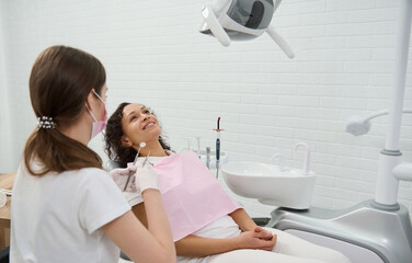 Beautiful woman in dentists chair during regular dental check-up in modern dentistry clinic. Oral...