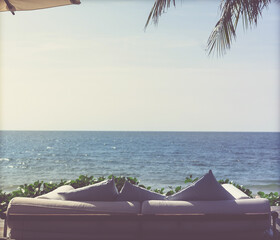 sofa chair beside beach for seeing view of the sea in hotel resort. intake film grain tone