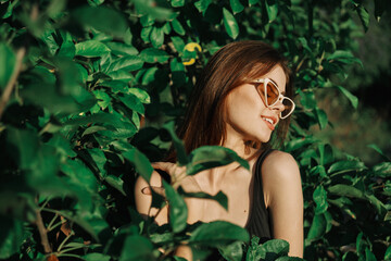smiling woman wearing sunglasses green leaves nature fashion