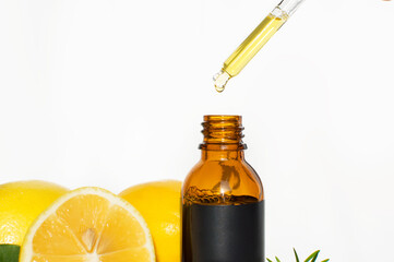The concept of natural care cosmetics
with a bottle of essential oil and serum on a white background and with lemon and green leaves. Flat composition with cosmetic products with place for text. 