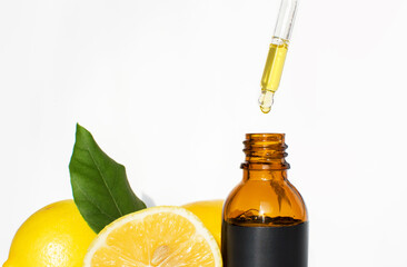 The concept of natural care cosmetics
with a bottle of essential oil and serum on a white background and with lemon and green leaves. Flat composition with cosmetic products with place for text. 