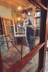 Young woman wearing apron working in the workshop