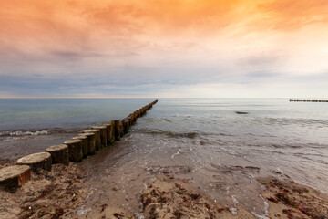 Wooden dock in the ocean. Colorful sky in the summer.