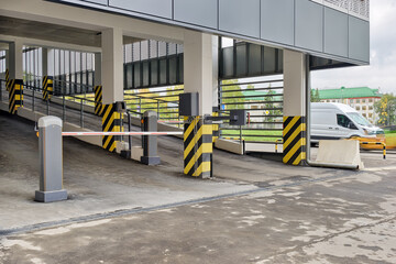Automatic barrier gate at the entrance to a typical multi-storey car park. Closed barrier of car...