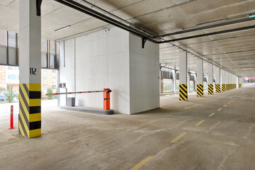Automatic barrier gate at the entrance to a typical multi-storey car park. Closed barrier of car...