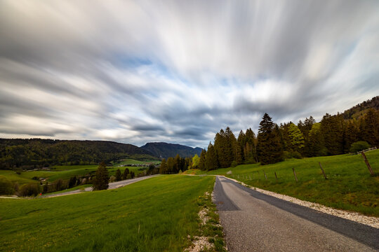 Road in a green field on a cloudy day