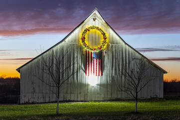 Barn decorated with a Christmas wreath and American flag © Dader/Wirestock