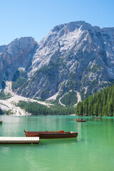 Obraz premium Lake Braies (also known as Pragser Wildsee or Lago di Braies) in Dolomites Mountains, Sudtirol, Italy. Romantic place with typical wooden boats on the alpine lake. Hiking travel and adventure.