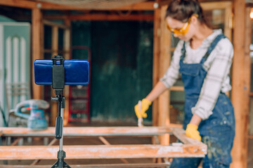 Young woman making video blog in the workshop