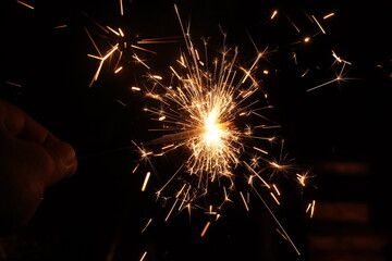 A burning sparkler on the black