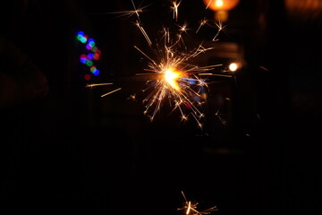 A burning sparkler on the black