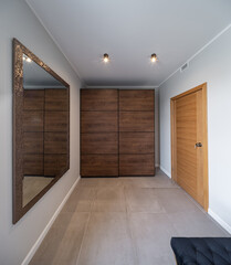 Modern interior of apartment. Entrance hall. Wardrobe. Mirror.